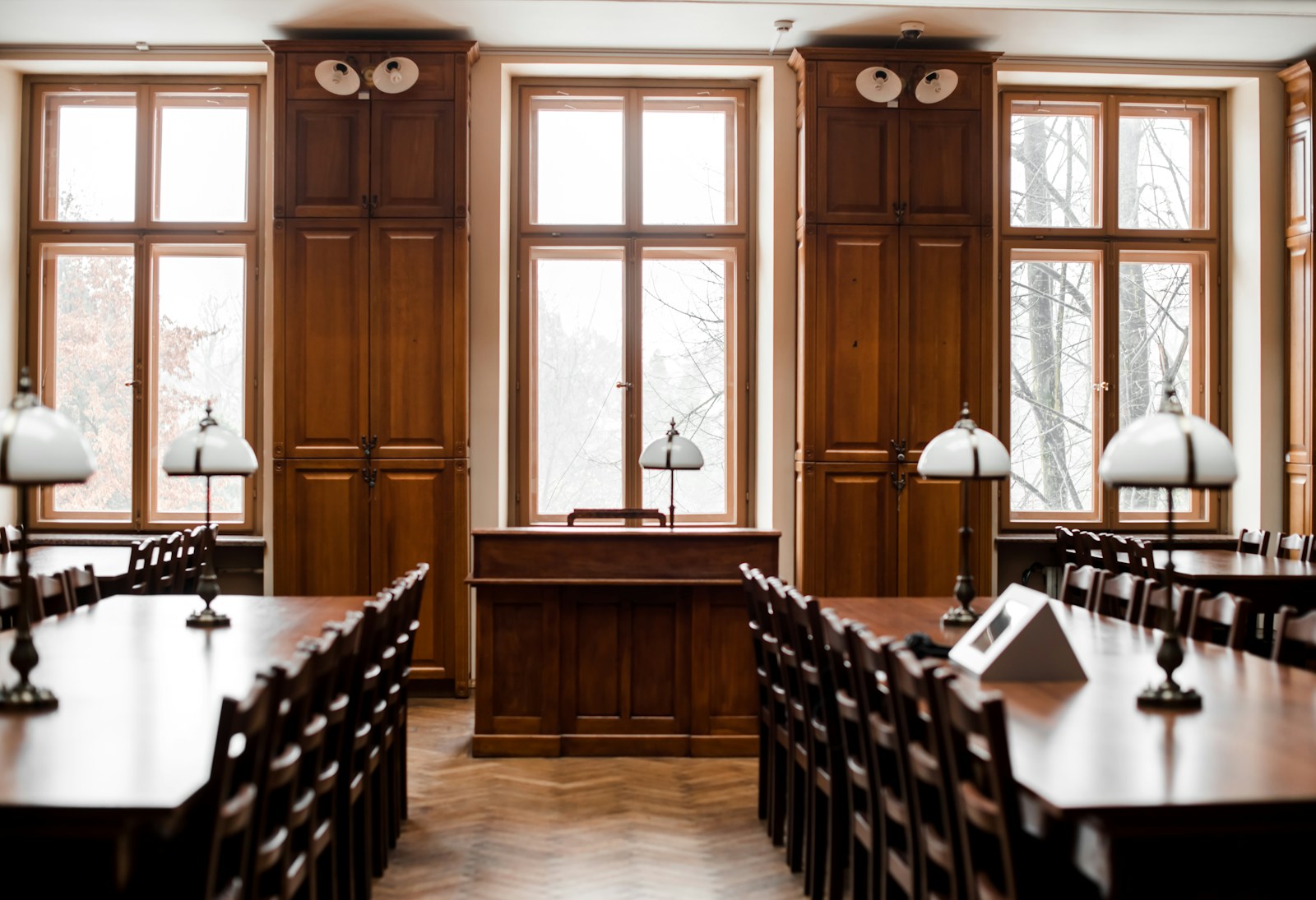 a room filled with lots of wooden tables and chairs